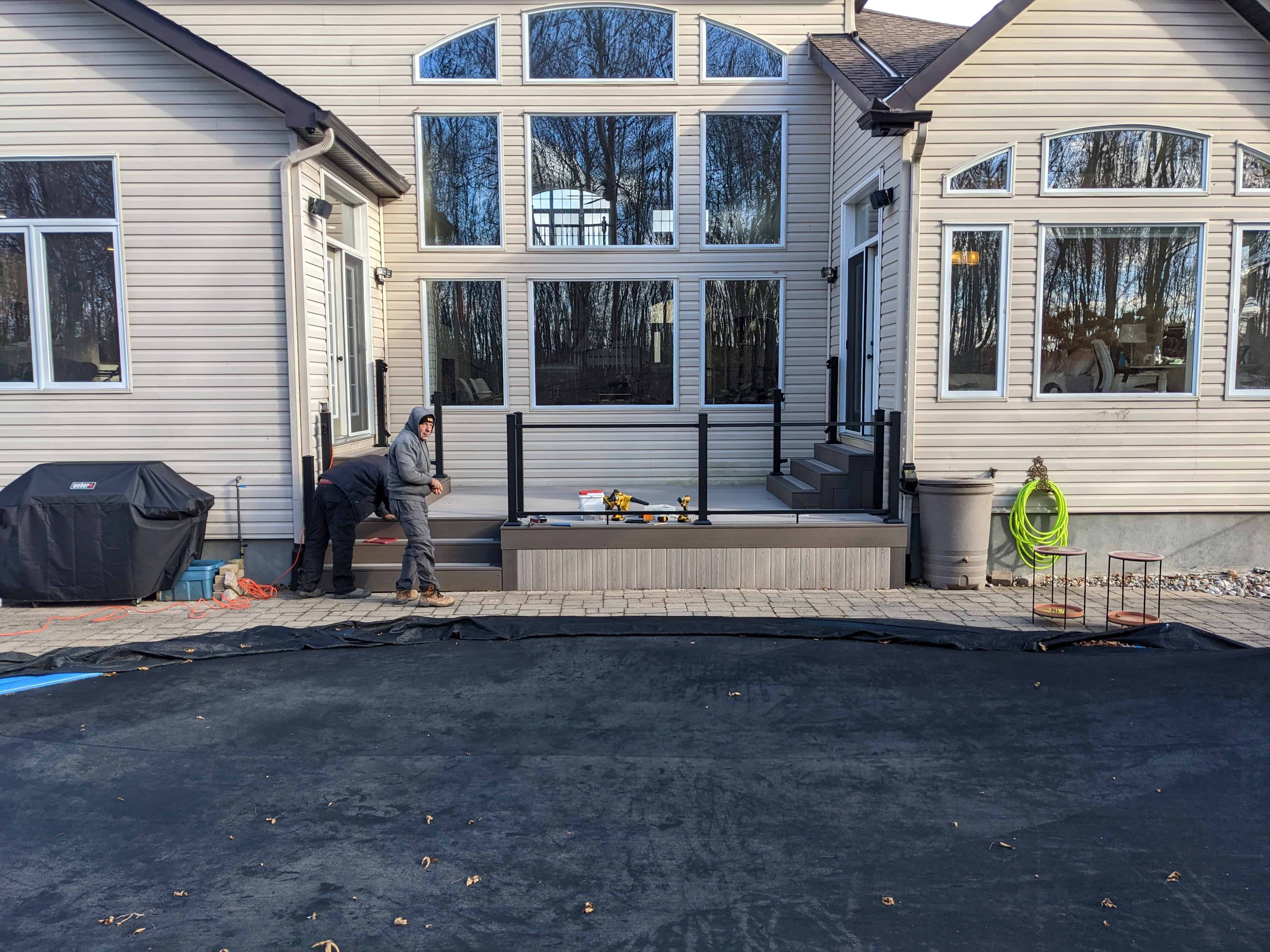 Low-maintenance poolside deck with glass railing in Ottawa
